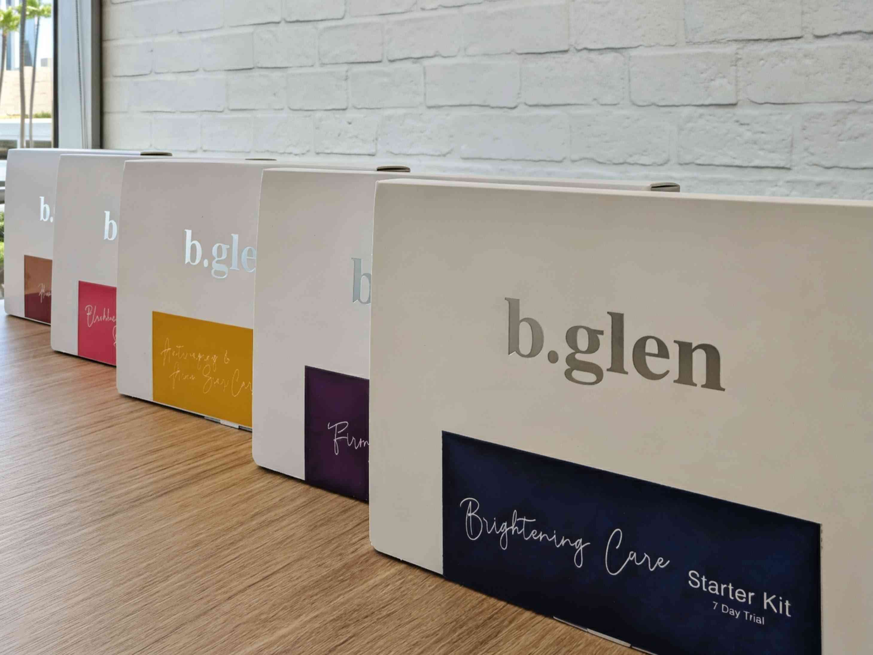The five b.glen Starter Kits lined up against the brick wall in natural light